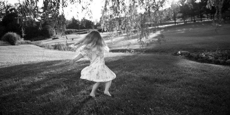  A child dances freely in the open field. 